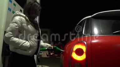加油站的年轻女子正微笑着为她的汽车加油